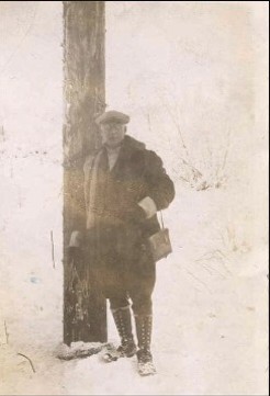 Frank I. Reed and one pole of an Anchorage Light and Power transmission line completed in 1928.